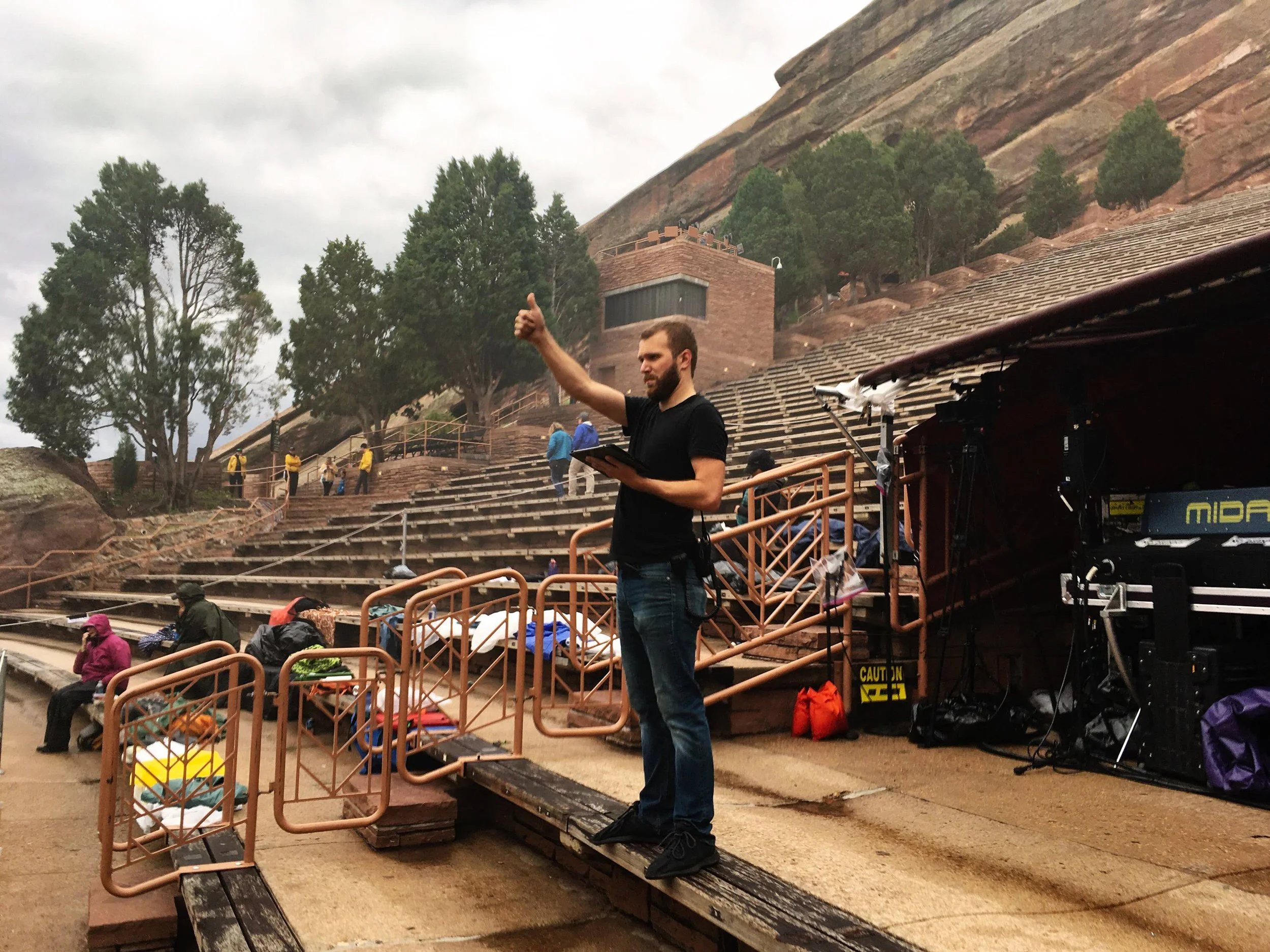 Zach Fichter at the front-of-house position in an outdoor amphitheatre, signalling to the stage